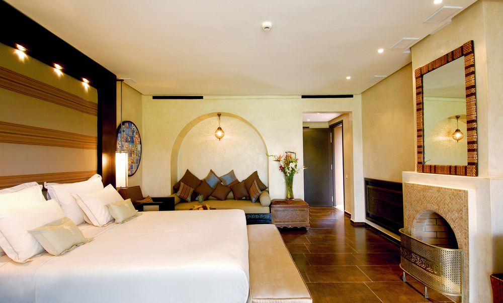 A calm hotel suite with a king bed and soft evening light