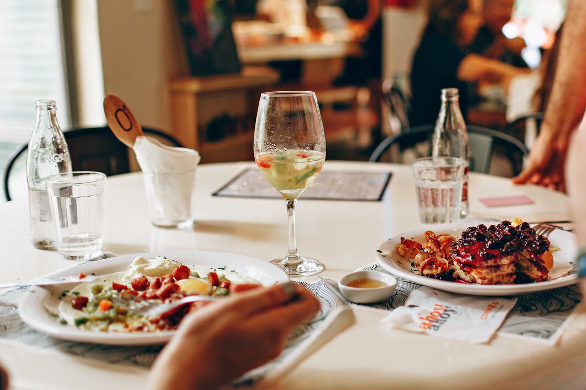 A restaurant table with plated dishes and glasses of wine