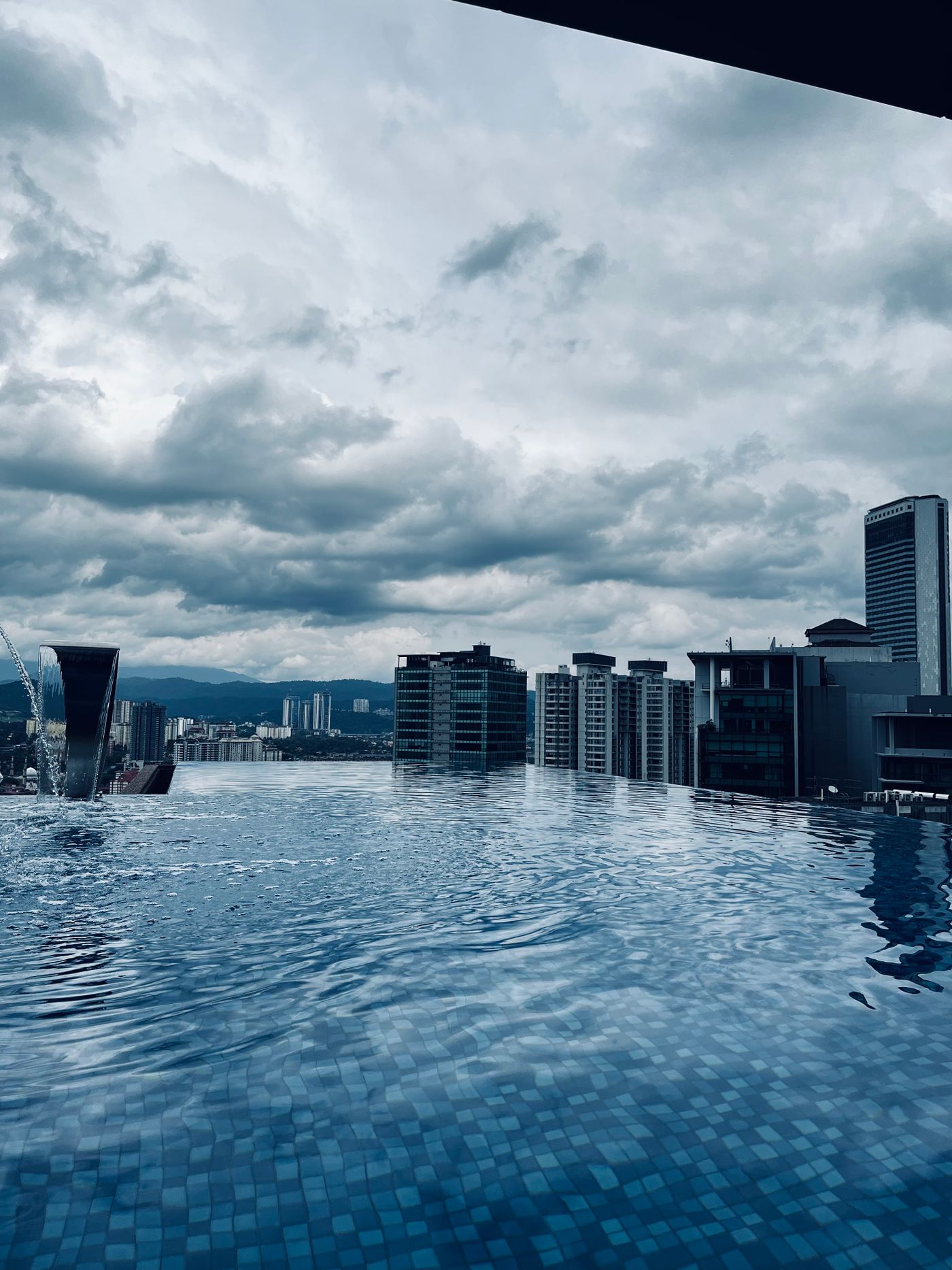 An infinity-edge pool on a high terrace, looking out over city towers