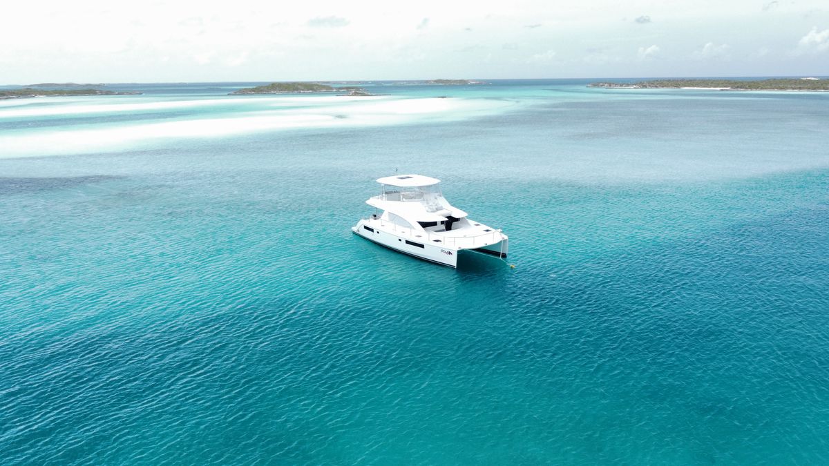 Aerial view of a white motor yacht on clear turquoise water