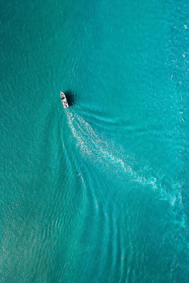 A boat leaving a white wake across turquoise water