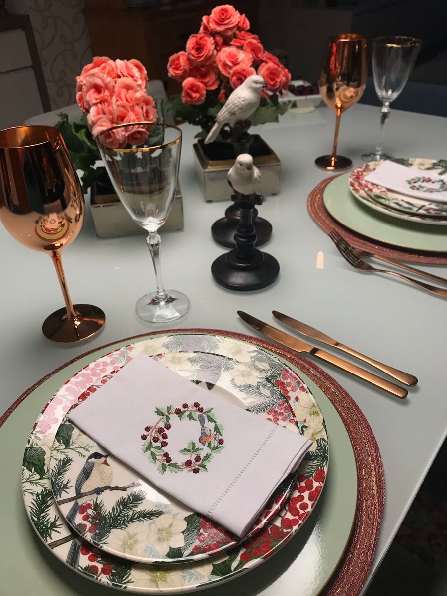 A dinner table set with patterned plates, cutlery and glassware