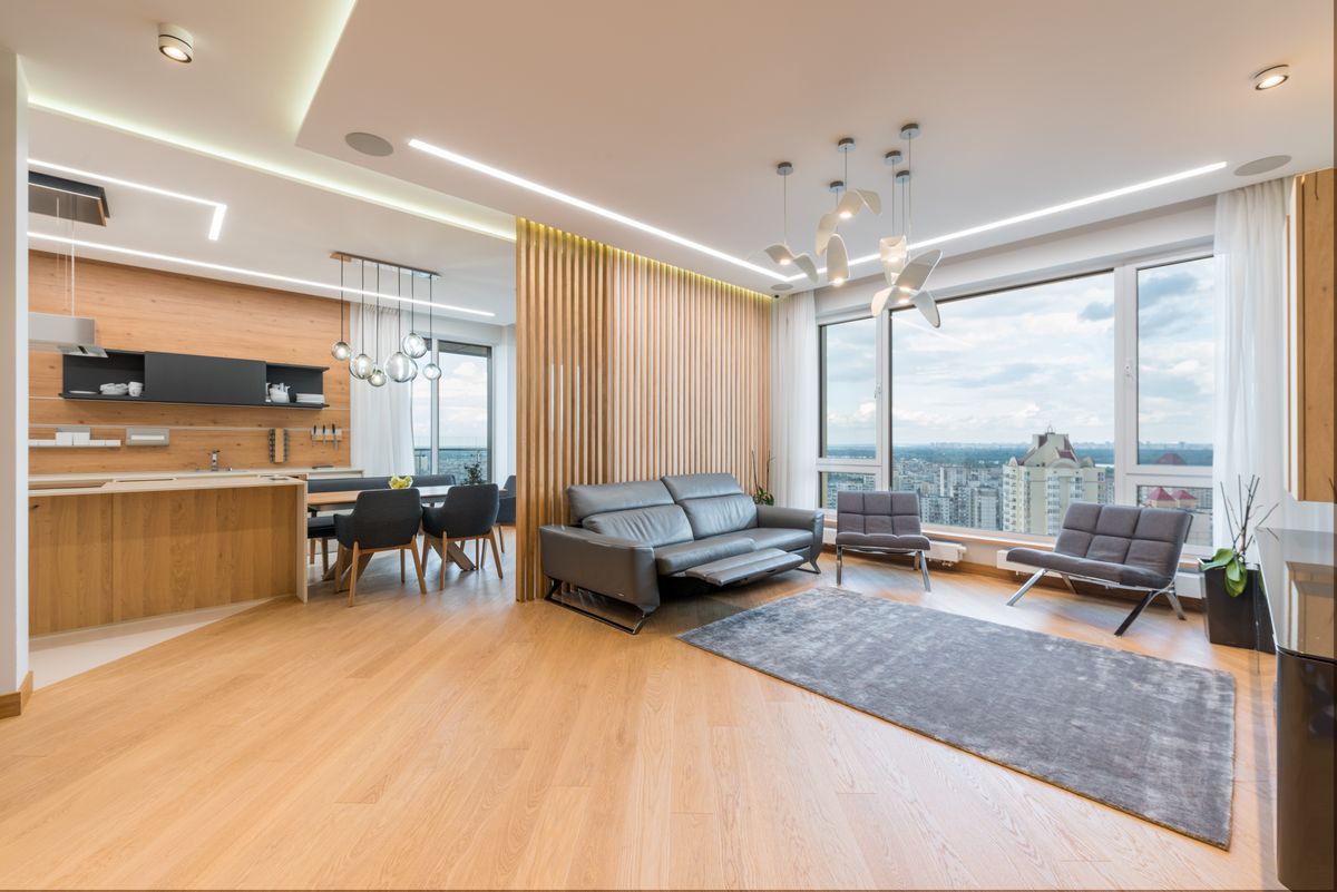 An open-plan apartment with a kitchen, dining table and city views