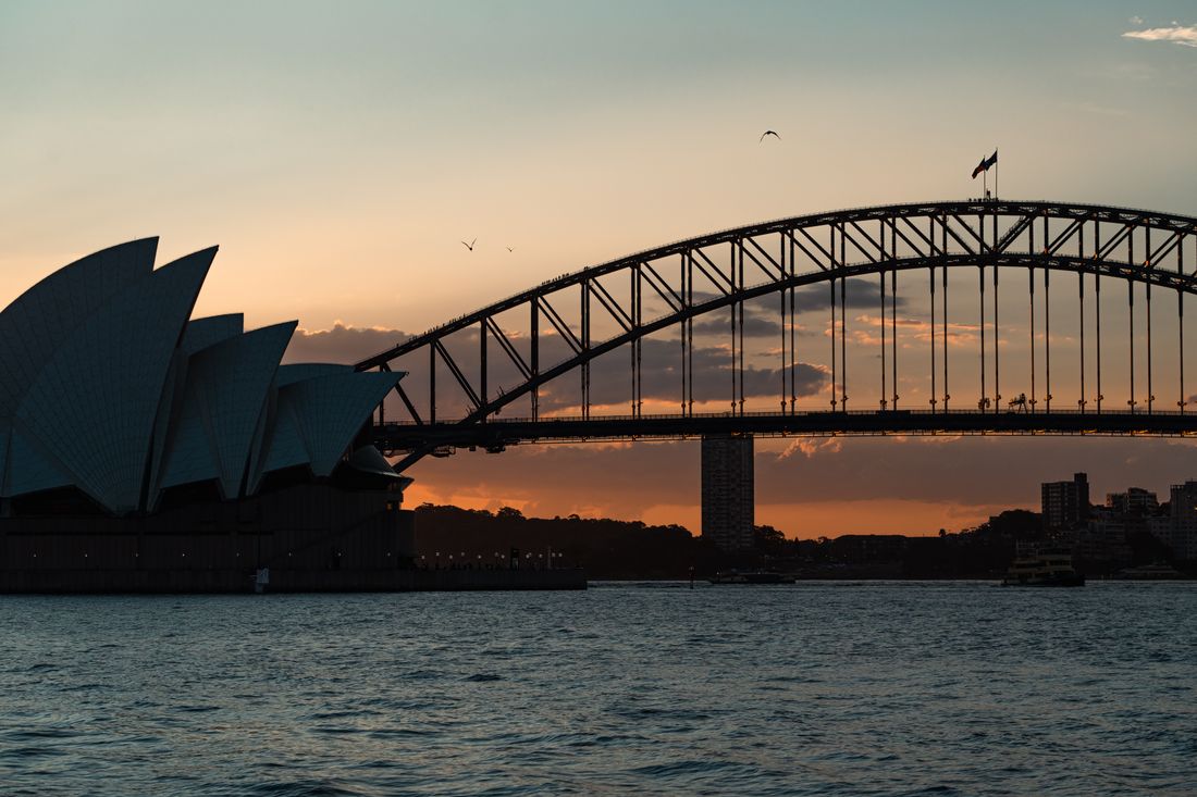The Sydney Opera House and Harbour Bridge silhouetted at sunset