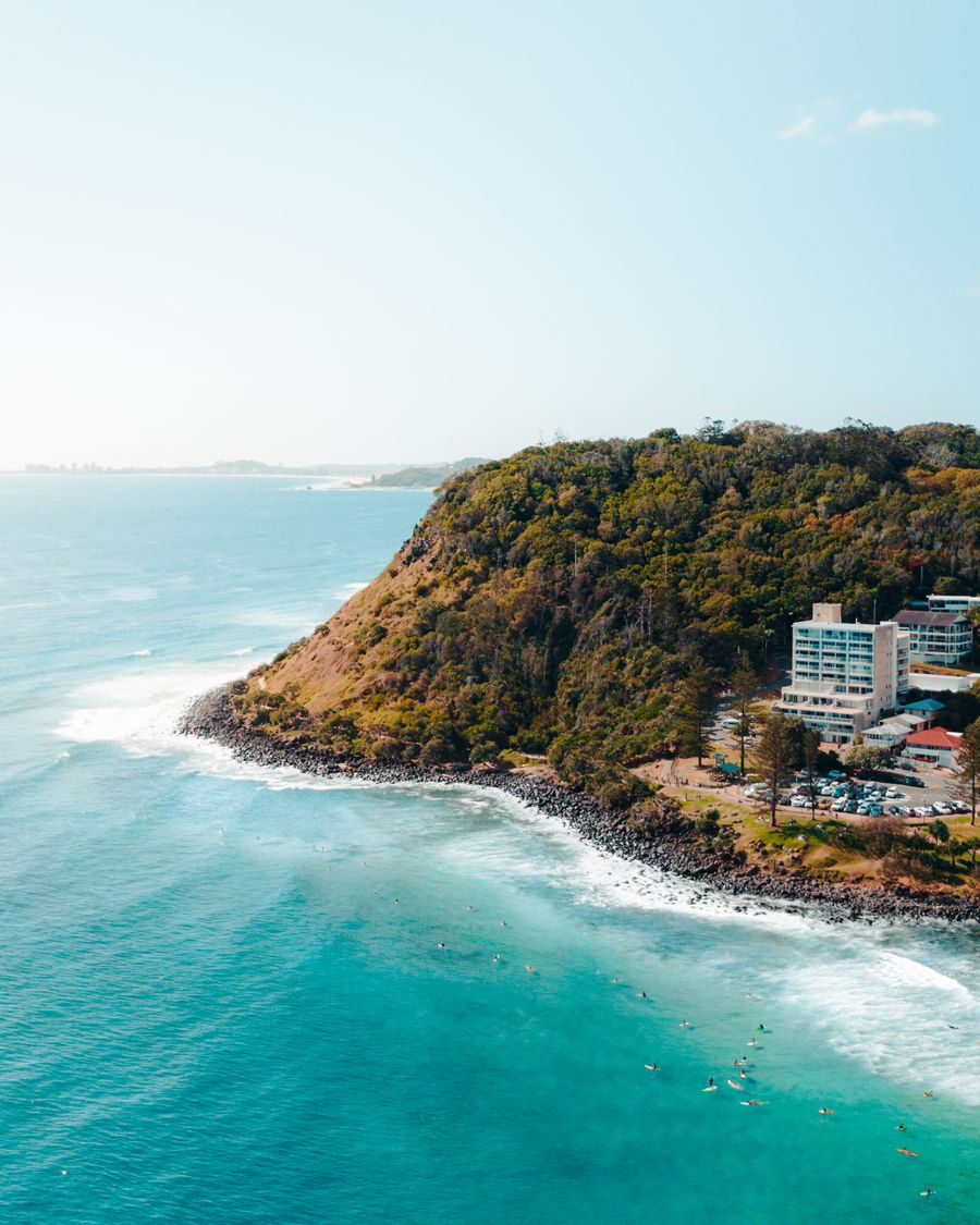 The forested headland at Burleigh Heads above turquoise surf