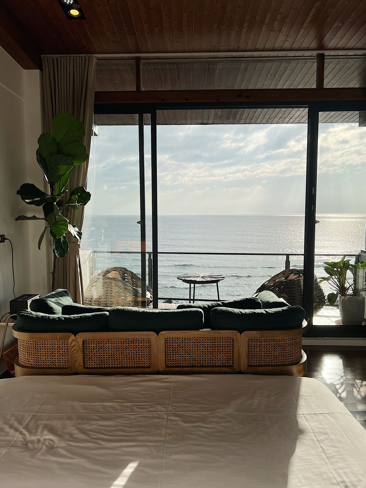 A hotel room with a large window looking out to the sea